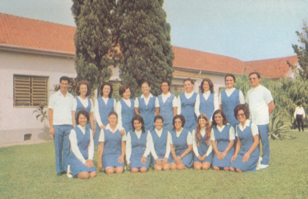 Grupo de estudantes de enfermagem em uniforme azul e branco em fotografia colorida.